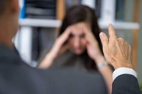 Man pointing at stressed woman - Hostile Work Environment